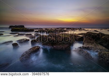 Amazing Seascape For Background. Beach With Rocks And Stones. Low Tide. Motion Water. Clear Sky. Sun