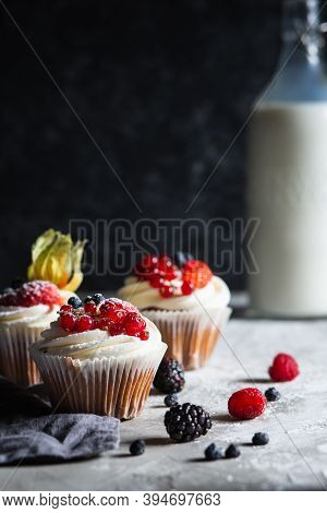 Homemade Muffin Next To A Bottle Of Milk On A Table And On A Dark Background With Fresh Berries Arou