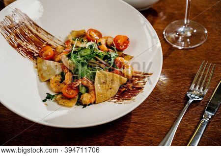 Fresh Salad Plate With Shrimp, Tomato And Mixed Greens On Wooden Background Close Up. Healthy Food.