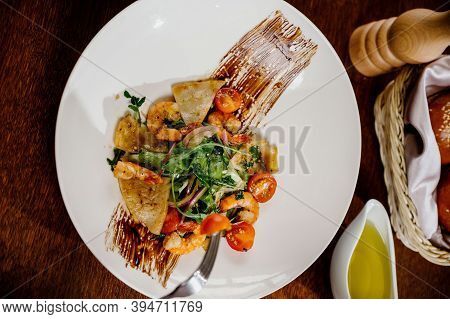Fresh Salad Plate With Shrimp, Tomato And Mixed Greens On Wooden Background Close Up. Healthy Food.