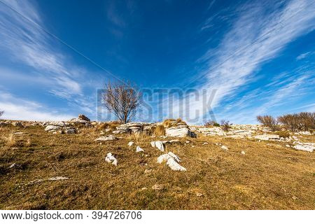 Landscape Of The Lessinia Plateau (altopiano Della Lessinia), In Autumn With Brown Meadow And Karst 