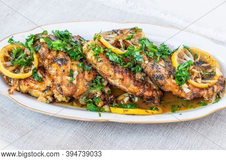 Chicken Francese - Fried Chicken Breast With Lemon Slices And Delicious Sauce On A White Plate Close