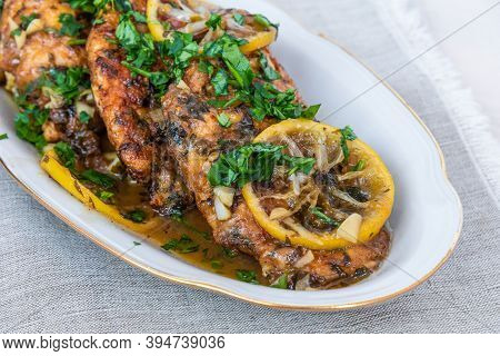 Chicken Francese - Fried Chicken Breast With Lemon Slices And Delicious Sauce On A White Plate Close