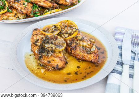Chicken Francese - Fried Chicken Breast With Lemon Slices And Delicious Sauce On A White Plate On Th