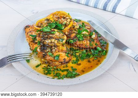 Chicken Francese - Fried Chicken Breast With Lemon Slices And Delicious Sauce On A White Plate Close