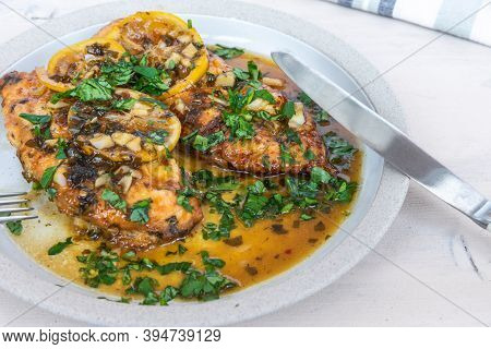 Chicken Francese - Fried Chicken Breast With Lemon Slices And Delicious Sauce On A White Plate Close
