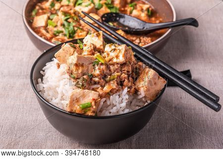 Traditional Chinese Sichuan Cuisine - A Bowl Of Rice With Mapo Tofu On A Rustic Background