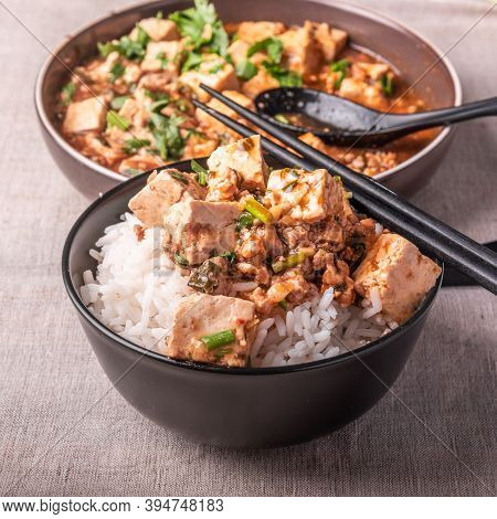 Traditional Chinese Sichuan Cuisine - A Bowl Of Rice With Mapo Tofu On A Rustic Background