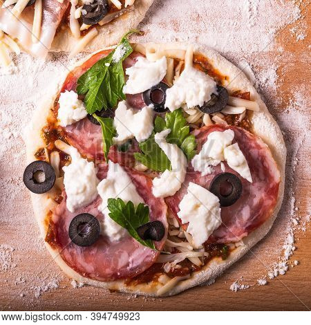 Cooking Traditional Italian Mini Pizza, Pizzetta - Raw Mini Pizza With Sausage And Mozzarella Cheese