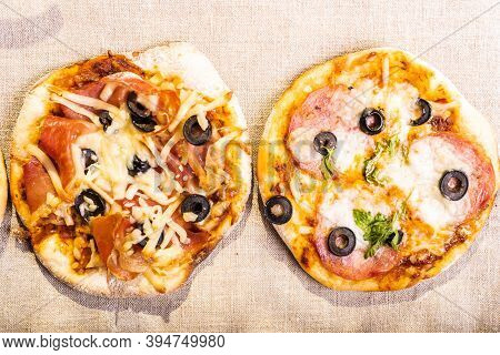 Two Ready-made Mini Pizza, Pizzetta With Sausage And Bacon, Jamon On A Linen Napkin - Neapolitan And