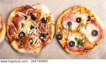 Two Ready-made Mini Pizza, Pizzetta With Sausage And Bacon, Jamon On A Linen Napkin - Neapolitan And