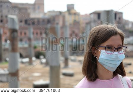 Young Girl With Surgical Mask While Visiting The City Of Rome In Italy And Ancient Traian Market In 