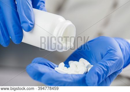 Doctor,nurse,gp Medical Practitioner Wearing Blue Surgical Latex Gloves Holding Medicine Bottle,taki