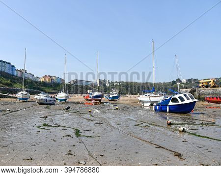 Tenby, Wales - April 15 2019 : The Boats In The Harbour At Tenby At Low Tide Showing The Mooring Cha
