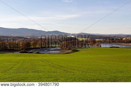 Czech Autumn Landscape. Dry Pond Dehtar With Meadow, Trees And Distant Hill At Autumn Day Time