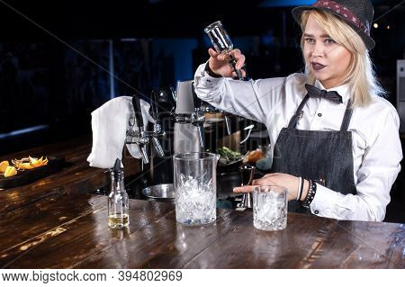 Focused Woman Bartender Formulates A Cocktail On The Bar