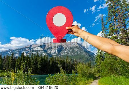 Creative Travel Destination Concept As A Person Is Seen Holding A Waypoint Marker Over A Mountain La