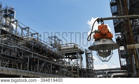 Industrial Explosion Proof Lantern On The Background Of The Refinery Plant And Classic Blue Sky.