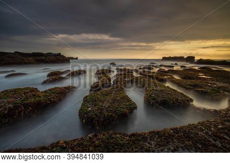 Amazing Seascape For Background. Beach With Rocks And Stones. Low Tide. Motion Water. Cloudy Sky. Sl