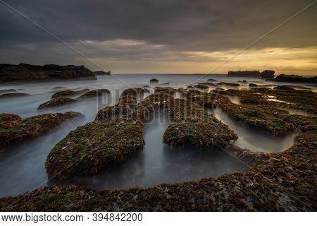 Amazing Seascape For Background. Beach With Rocks And Stones. Low Tide. Motion Water. Cloudy Sky. Sl
