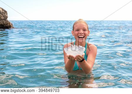 Happy Teenage Girl Caught Large Jellyfish In Water Sea On Beach. Danger Of Burns Or Sting Scyphozoa.