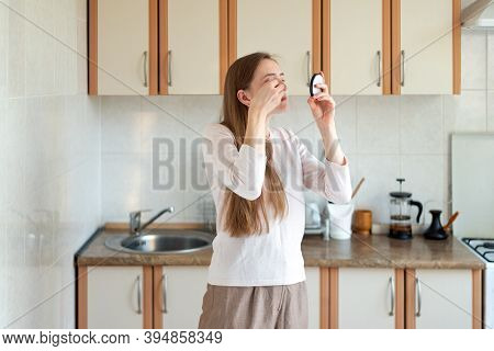 Girl Doing Make Up In Kitchen And Looking In Small Mirror. Hurrying To Work.