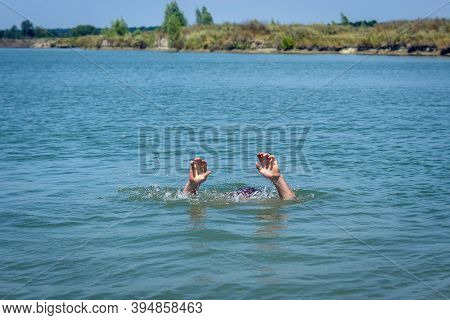 Hands Of A Drowning Man Above Water In Need Of Help.