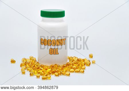 Health Care - Nutritional Supplement - Bottle Of Coconut Oil With Scattered Gold Gel Capsule On The 