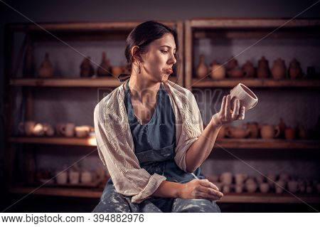 Pottery Girl Demonstrates A Finished Clay Bowl In Workshop. The Concept Of Craft Creativity.