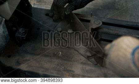 A Worker With Gloves Tightens The Bolts In A Metal Machine