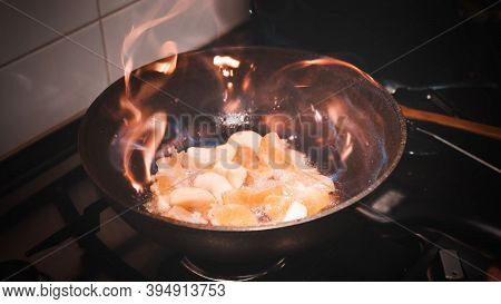 Open Fire In A Skillet The Apple And Orange Are Fried. Home Kitchen
