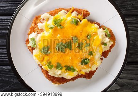 Fried Chicken Fillet Baked With Bechamel Sauce And Cheddar Cheese Close-up In A Plate. Horizontal To