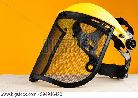Yellow Construction Mask-grid On A Wooden Table On A Yellow Background