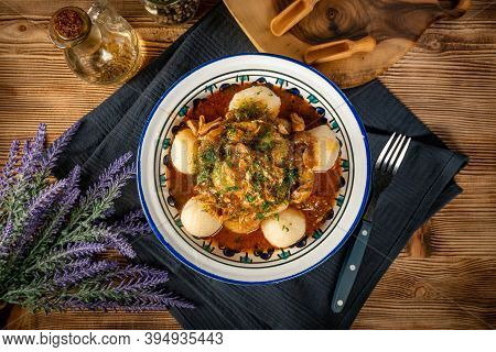 Dumplings With Turkey And Chorizo Sauce In A Painted Bowl.