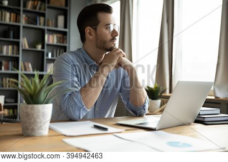 Pensive Businessman Sits At Workplace Desk Look Out The Window