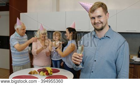 Portrait Of Handsome Caucasian Birthday Man Holding Glass Of Champagne Looking At Camera. Positive Y