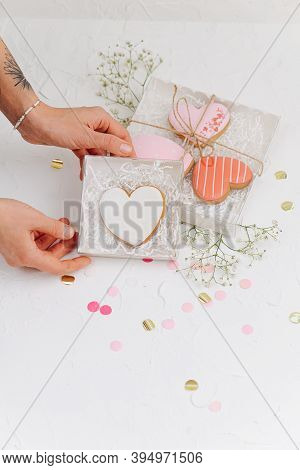Hands Holding Box Casing With Scarlet Heart Shaped Cookie
