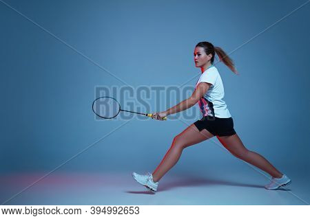 On The Run. Beautiful Handicap Woman Practicing In Badminton Isolated On Blue Background In Neon Lig
