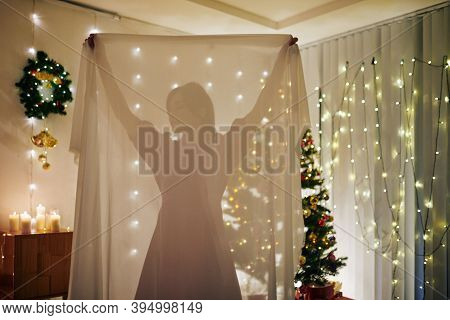 Young Woman Taking Transparent Table Cloth When Decorating Room For Christmas Celebration