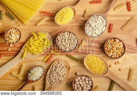 Flat Lay Food Background Made Of Legumes Cereals Pasta And Grains In Wooden Spoons On Kitchen Table