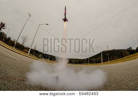 model rocket launch in parking lot on cloudy day