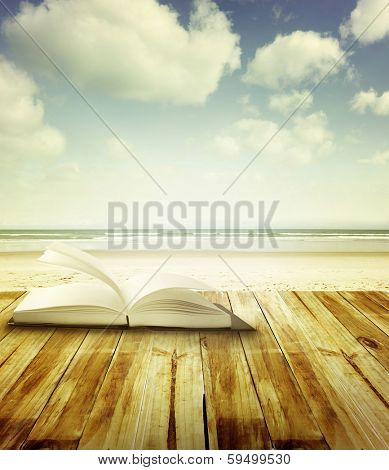 Open book on deck in front of beach scene