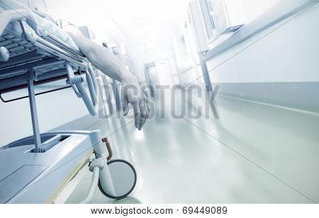 Hand Of A Dying Patient Lying On A Mobile Bed In Hospital Corridor