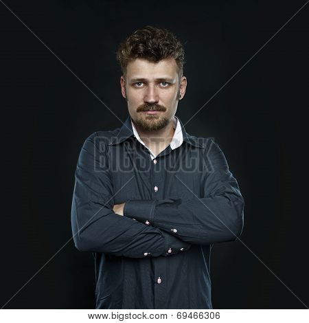 Serious manager with crossed hands, dark background