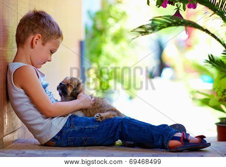 Young Boy Hugging Little Puppy