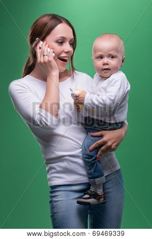 Mother holding toddler son with toy phone