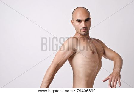 Topless man posing weird, enhancing his chest.