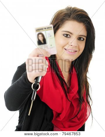 Close-up of a pretty teen girl happily holding up her new driver's license for the viewer to see, along with a car key.  Focus on teen.  On a white background.