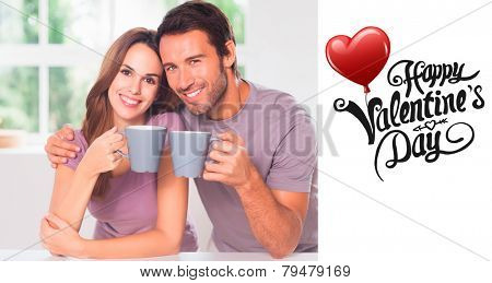 Couple looking at the camera with a coffee against cute valentines message