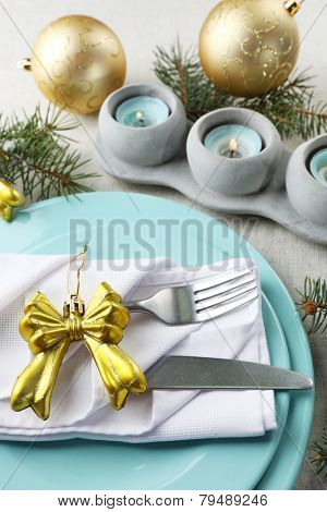 Christmas table setting in blue, golden and whitec olors on grey tablecloth background